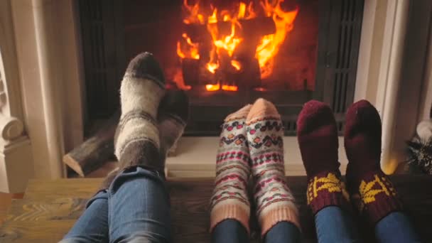 Slowmo van familie opwarming van de aarde en drogen van de voeten bij het branden van de open haard in huis — Stockvideo