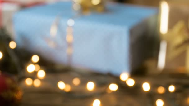 クリスマス ギフトや、木製のテーブルに飾りのフォーカス映像から 4 k ドリー。多重ビデオ。新年と冬の休暇に最適 — ストック動画