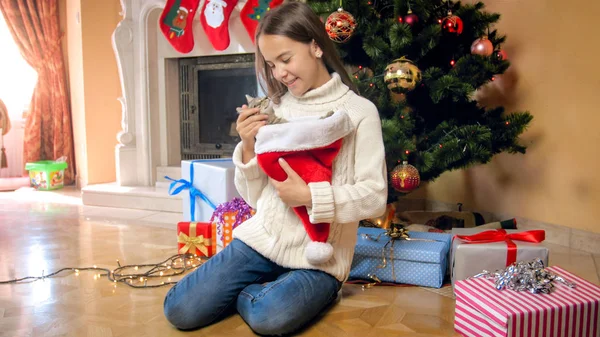 Šťastné děvče, které si pod vánočním šketem hladil její roztomilou kočku — Stock fotografie