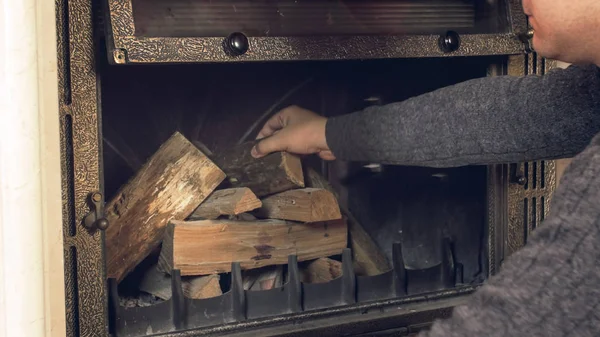 Genç adam evde açık şömine günlükleri atma