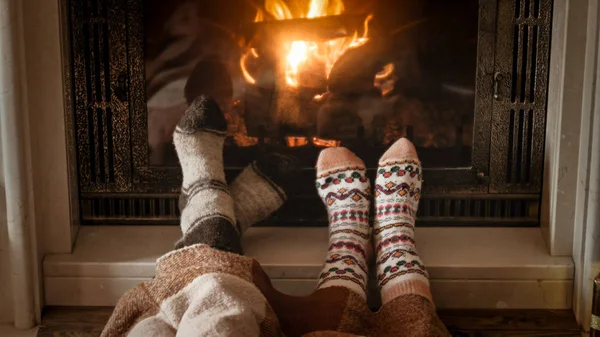 Man and woman warming and relaxing by the fireplace at cold day — Stock Photo, Image
