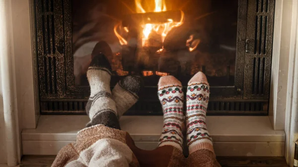 Young couple in love in knitted warm socks lying next burning fi — Stock Photo, Image