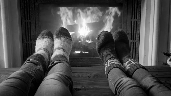 Black and white image of couple in knitted socks relaxing by the — Stock Photo, Image