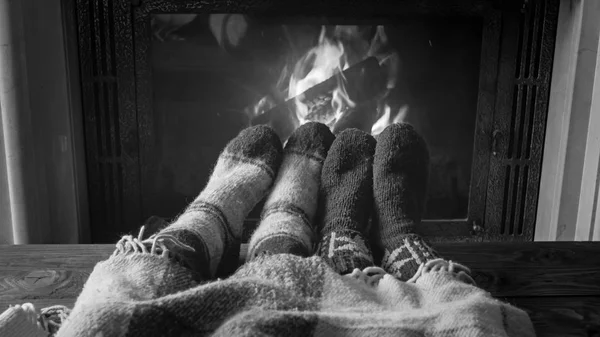 Imagem preto e branco de pés em meias de lã quente deitado sob bla — Fotografia de Stock