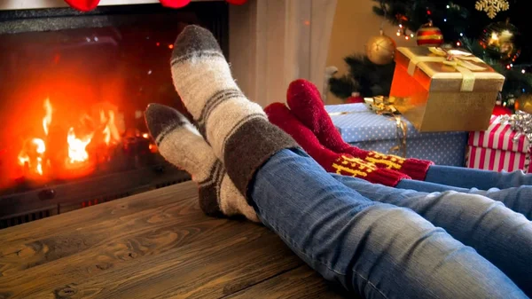 Family in wool socks relaxing by the fireplace at room decorated — Stock Photo, Image
