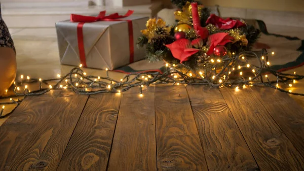 Toned image of empty wooden desk against gifts, glowings lights — Stock Photo, Image