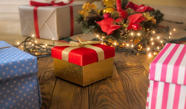 Belle boîte cadeau rouge avec ruban doré sur le sol en bois recommence — Photo