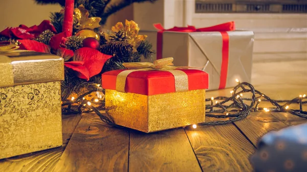 Karácsony háttere lett. Arany ajándék doboz, koszorú és izzó — Stock Fotó
