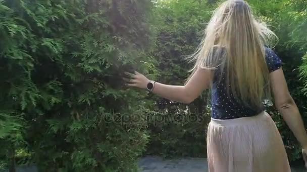 Slow motion video av glada leende kvinna körs bort från kameran på park och titta över hennes axel — Stockvideo