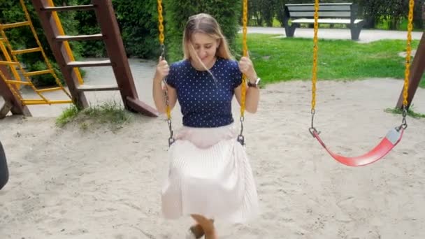4K video de feliz sonriente mujer divirtiéndose en swing en parque — Vídeo de stock