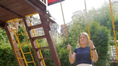 salıncak Bahçesi, güneşli gün sürme güzel gülümseyen kadın 4 k video