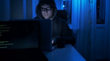 4 k görüntüleri gözlük ve laptop çalışma gece başlık giyen genç erkek hacker