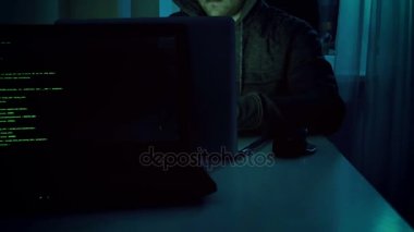 genç erkek hacker'laptop evde gece çalışma hoodie 4 k görüntüleri. Siber suç için mükemmel video