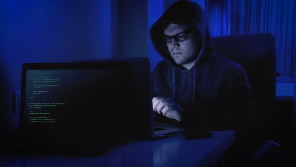 Запись хакера в толстовке и очках, пытающегося взломать код безопасности — стоковое видео