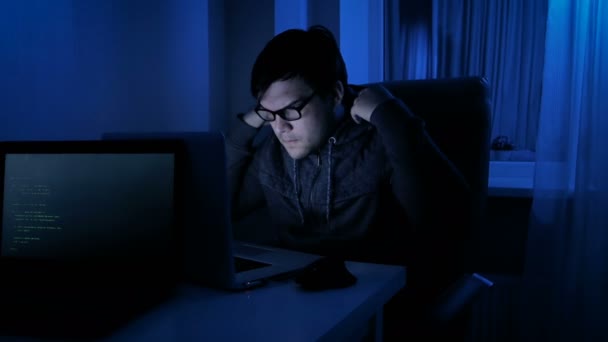 Funny 4k footage of male pretends to be hacker. Man working on laptop at night — Stock Video