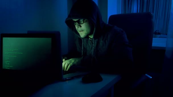 Funny 4k footage of male pretends to be hacker. Geeky man in hood working  on laptop at night — Stock Video © Kryzhov #178445572