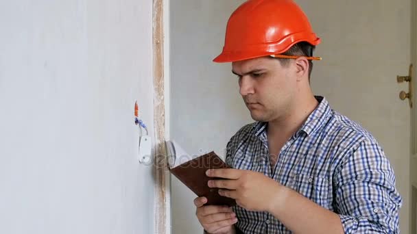 Ağır çekim görüntüleri gelen genç adamdır defterindeki çiziminden ev yenileme hakkında notlar yapma — Stok video