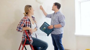 Genç çift boyama duvarları boya rulo yeni evlerine ağır çekim görüntüleri