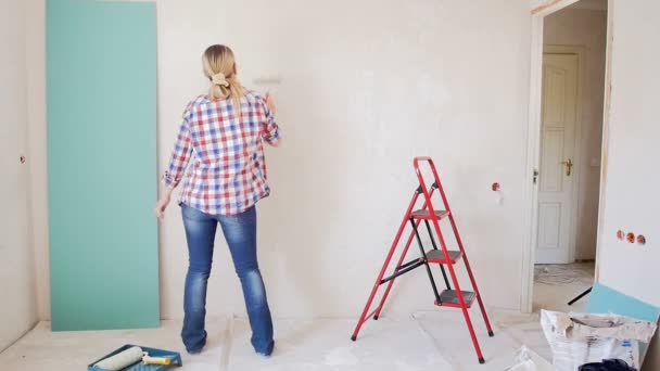 Filmagem de mulher alegre feliz dançando enquanto faz renovação no novo apartamento — Vídeo de Stock