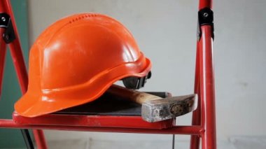 Çalışma araçları ve kırmızı kask bir merdiven House yenileme altında yatan kaydırma