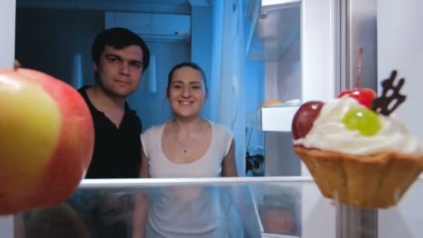 Imágenes de 4k de la familia joven buscando algo para comer por la noche — Vídeos de Stock