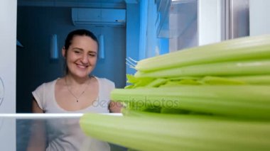 4 k görüntülerini alarak ve kereviz buzdolabından geceleri yemek mutlu gülümseyen kadın