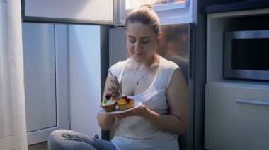 Güzel ve genç birbayan mutfak gece yarısı pasta yemeye Slow motion video