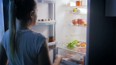 Genç kadın celerfy pasta yerine buzdolabından alarak. Sağlıklı beslenme ya da video diyet için mükemmel