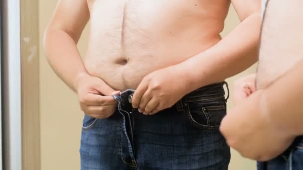4 k video člověka, aby se vešly velké pivní břicho v těsné džíny — Stock video
