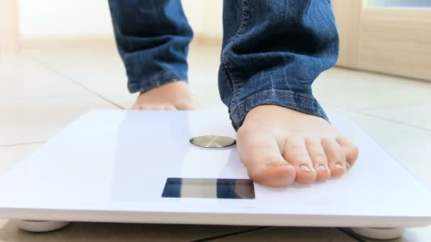 4k video of young woman checking her weight on electronic scales — Stock Video