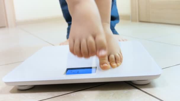 4k closeup video of baby and mothers feet standing on weight scales — Stock Video