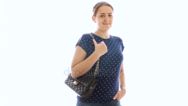 Vidéo 4k de belle jeune femme avec sac à main posant à la caméra sur fond blanc — Video