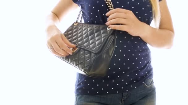 黒革製のハンドバッグから携帯電話を取る若い女性の 4 k のクローズ アップ映像 — ストック動画