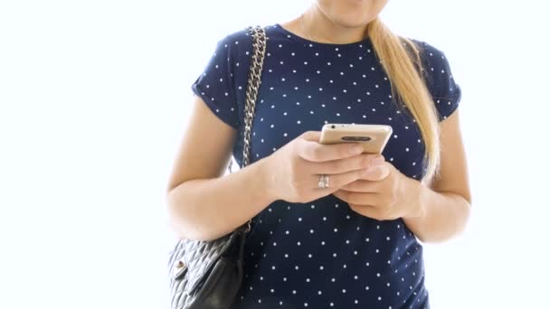 4k imagens de jovem bela mulher digitando número e falando por telefone celular contra fundo branco isolado — Vídeo de Stock