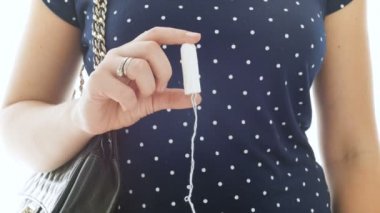 Adet tampon tutan genç kadın portre 4k görüntüleri