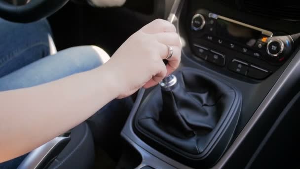 Closeup slow-motion beelden van jonge vrouw rijdt auto met handgeschakelde versnellingsbak — Stockvideo