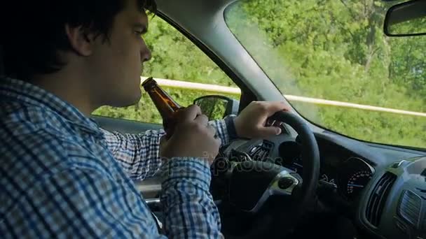 Slow motion beelden van onverantwoordelijke mannelijke stuurprogramma het drinken van alcohol tijdens het auto rijden — Stockvideo