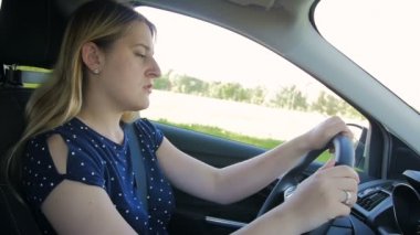 Ağır çekim görüntüleri pek genç kadının yorgun ve araba sürüş sırasında uykuya dalar