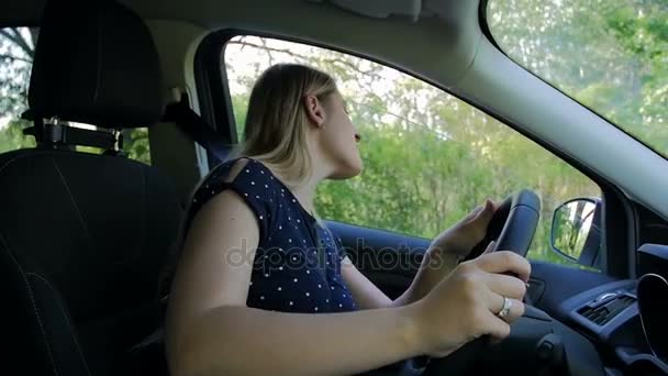 Zeitlupenaufnahmen von wütender Frau, die sich beim Autofahren gestresst fühlt — Stockvideo