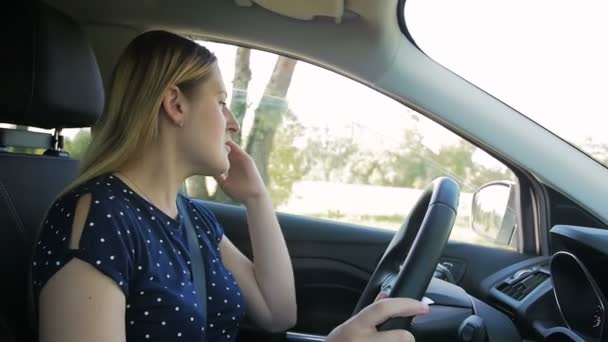 Vídeo en cámara lenta de una mujer joven estresada gritando a comportarse agresivamente mientras conduce el coche — Vídeos de Stock