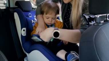 Anne ayarlama kemer onun Childs'ın Emanet araba koltuğu üzerinde gülümseyen genç 4 k video