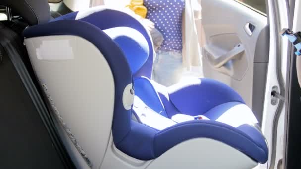 4k imagens de jovem mulher sentando seu filho bebê em assento de segurança infantil no carro — Vídeo de Stock