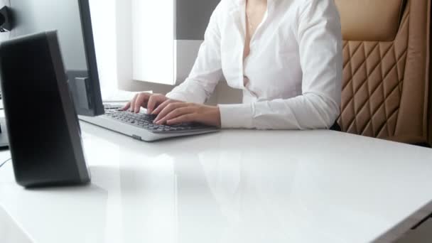 4k. 美丽微笑的女实业家的镜头坐在办公室的现代白色办公桌后, 在电脑上工作 — 图库视频影像