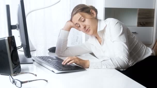 4 k beelden van jonge overwerkte zakenvrouw in slaap vallen op kantoor tijdens het werken op de computer — Stockvideo