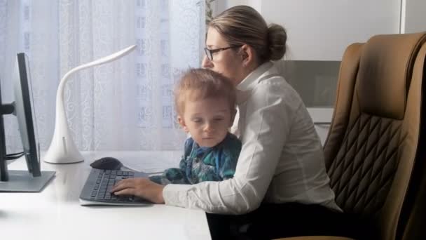 4 k video van elegante jonge zakenvrouw praten via de telefoon en werken op de computer tijdens de vergadering met haar baby op kantoor — Stockvideo