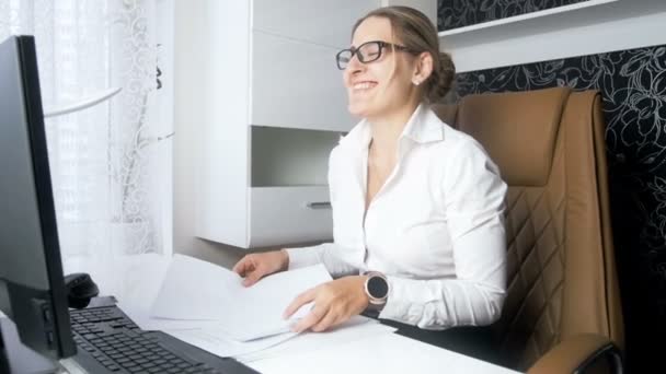 Zeitlupenvideo einer fröhlichen Geschäftsfrau, die im Büro stapelweise Dokumente und Papiere in die Luft wirft — Stockvideo