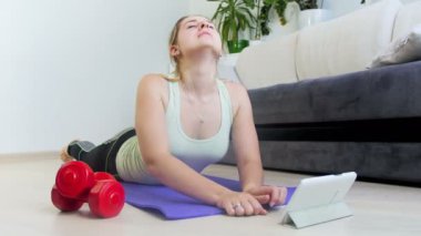 evde fitness mindere yalan ve dijital tablet kullanarak genç sportif kadın 4 k görüntüleri