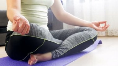 Evde pratik yoga closeup genç kadın kadın 4k video eller