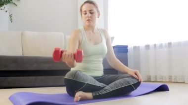 Halter kaldırma ve evde fitness mindere egzersiz yaparken yaralanan genç kadın kolu 4 k görüntüleri