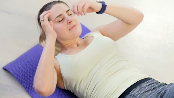 Vidéo au ralenti de belle jeune femme utilisant un tracker de fitness avant l'exercice à la maison — Video